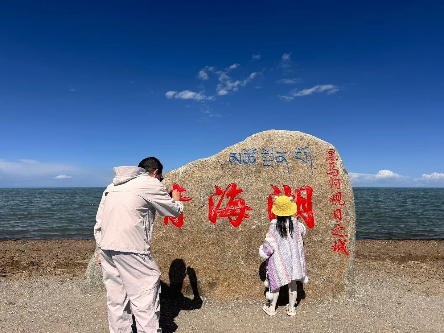 青海湖边,一家人在湖边石碑前留影